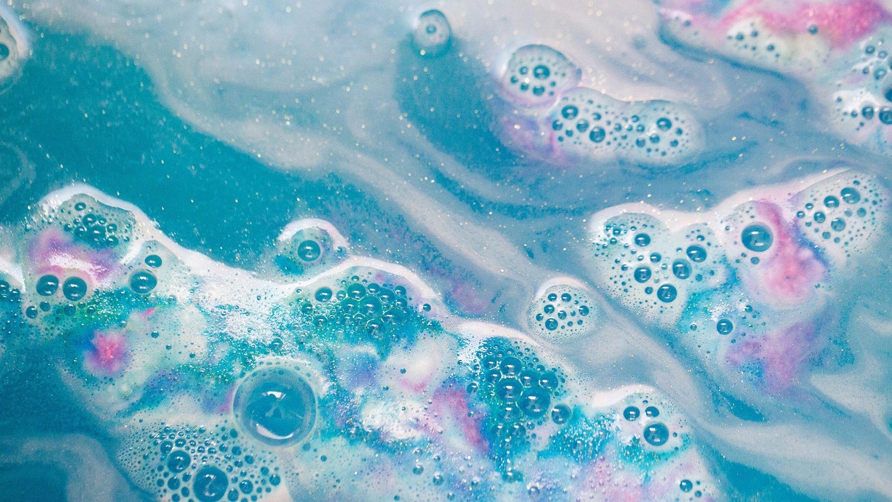 Пенистая жидкость. Мыльная пена. Красивая пена мыльная. Бомбочки для ванны разноцветные. Цветная вода в ванной.
