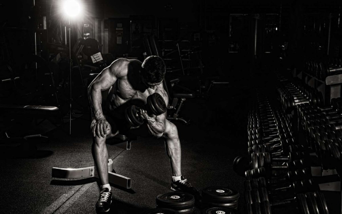 Спортивный парень с гантелей