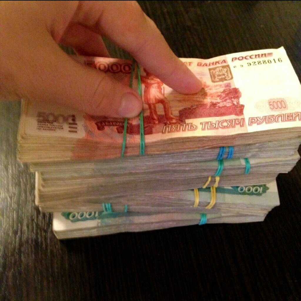 Пачка денег в руках рубли