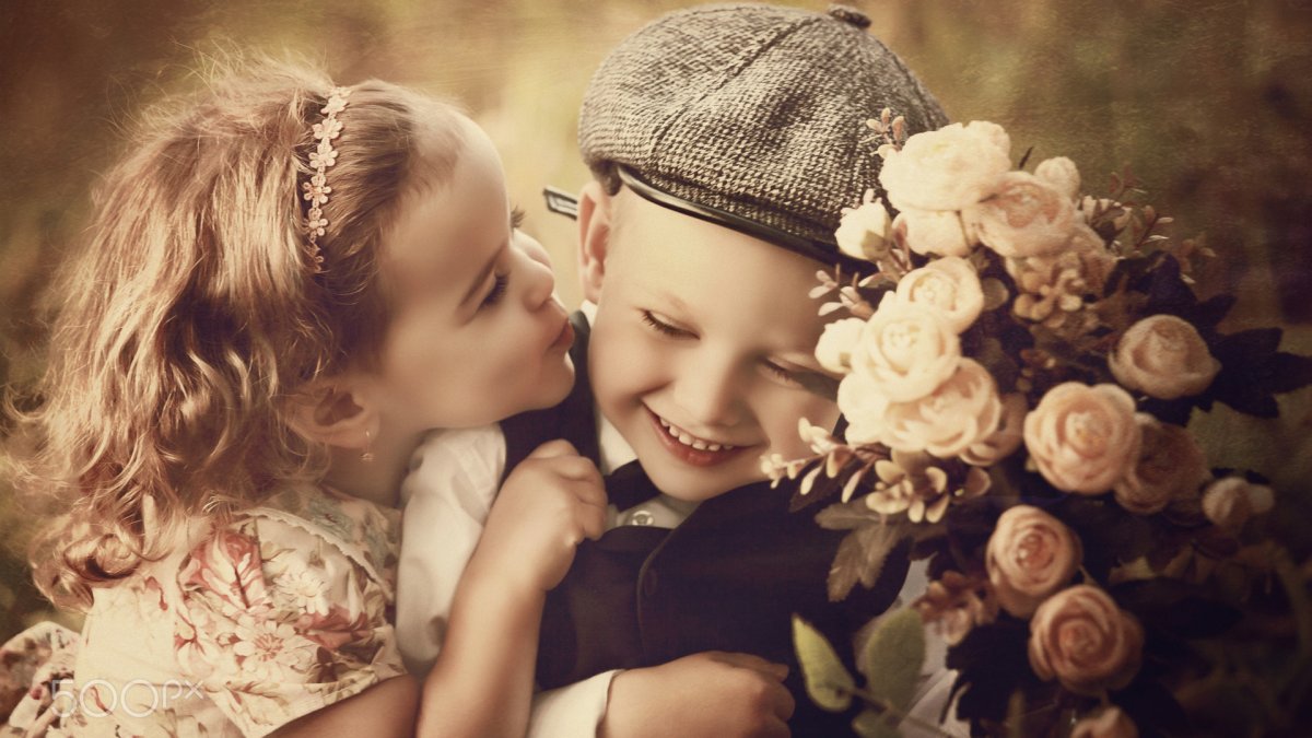 Мальчик целует девочку