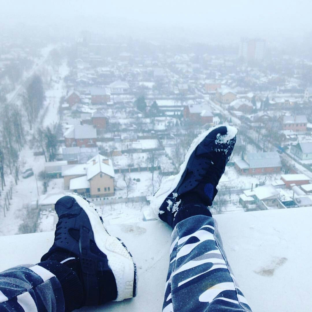 Ноги на краю крыши зимой