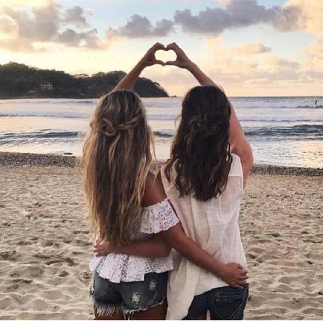 Подруги показывают сердце