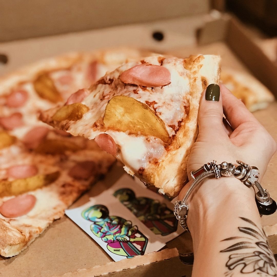 Фотографирует пиццу