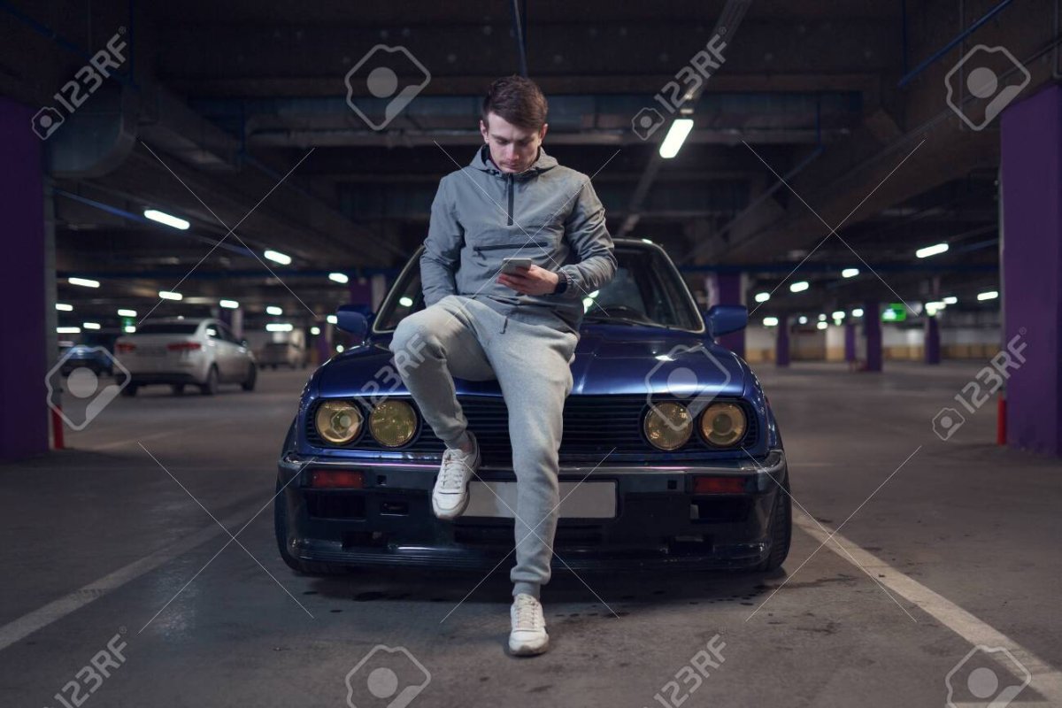 Парень сидит на машине